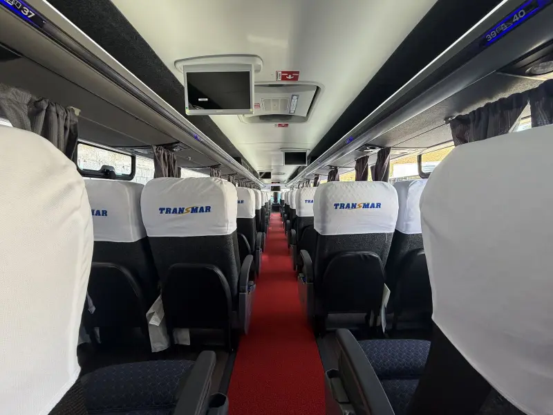 Poltronas com a marca Transmar no interior do ônibus de turismo