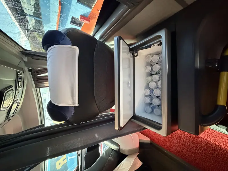 Corredor interno do ônibus de turismo Transmar com poltronas azuis